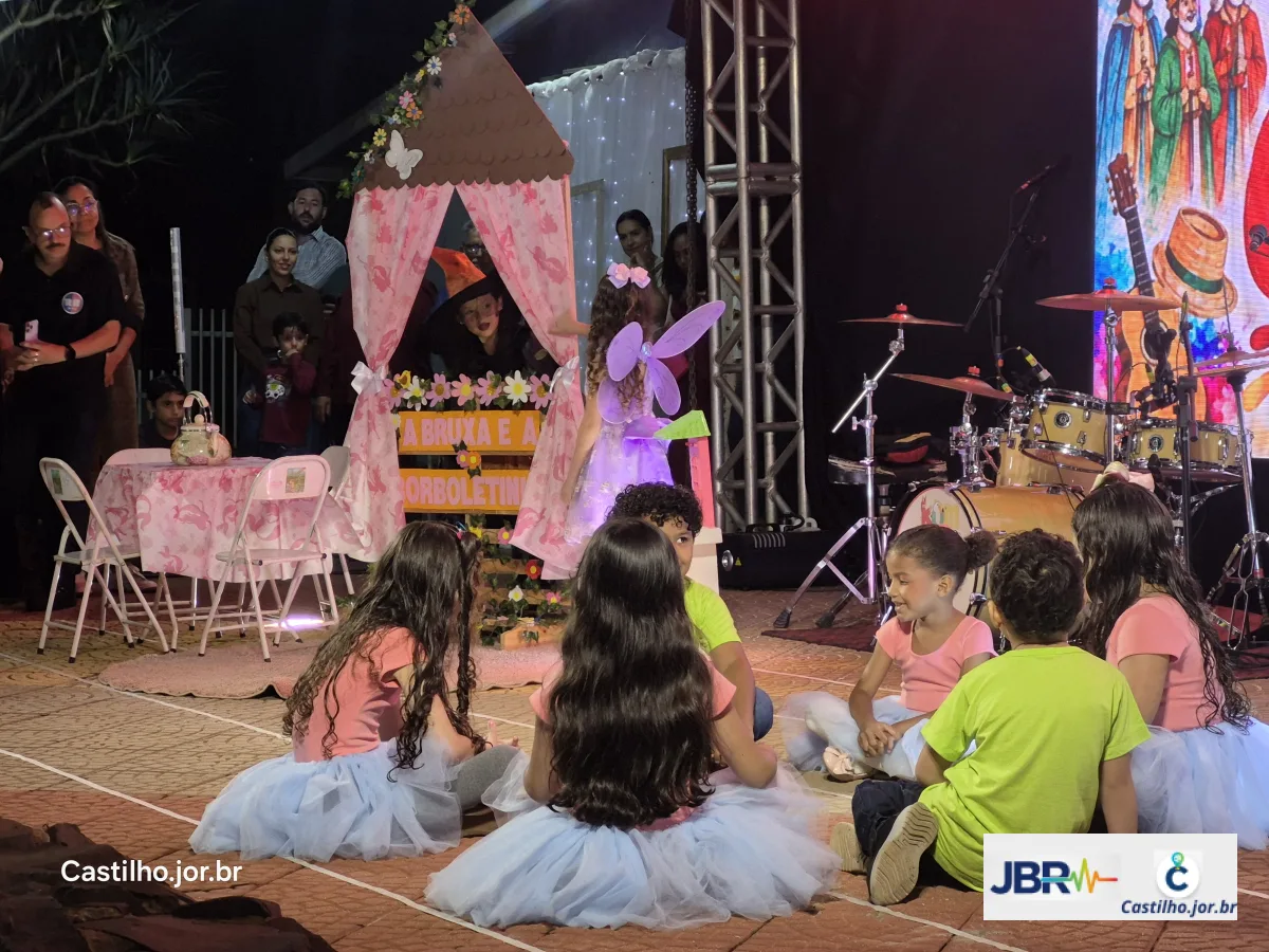 Crianças e adultos junto a cenário decorado ao lado do palco