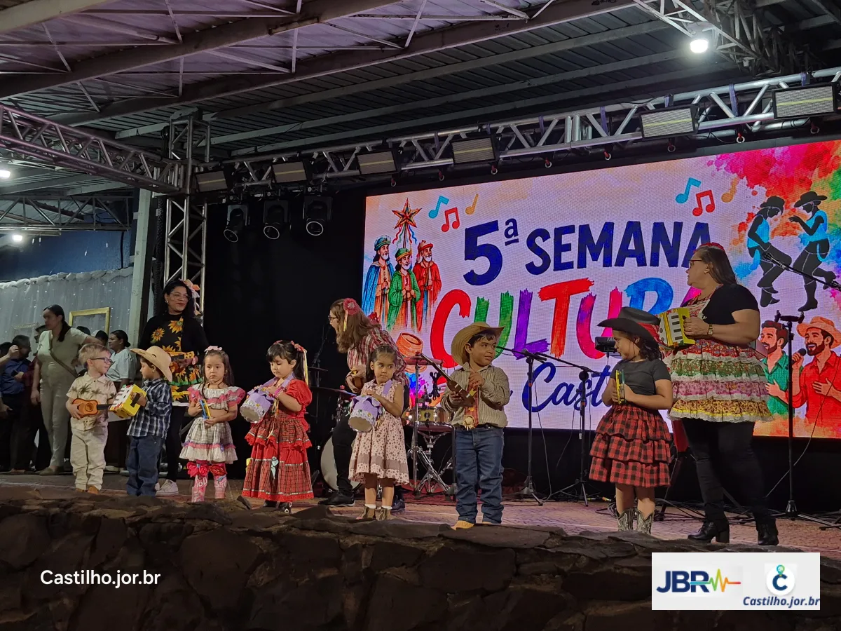 Grupo de crianças com roupas caipiras no palco do evento cultural