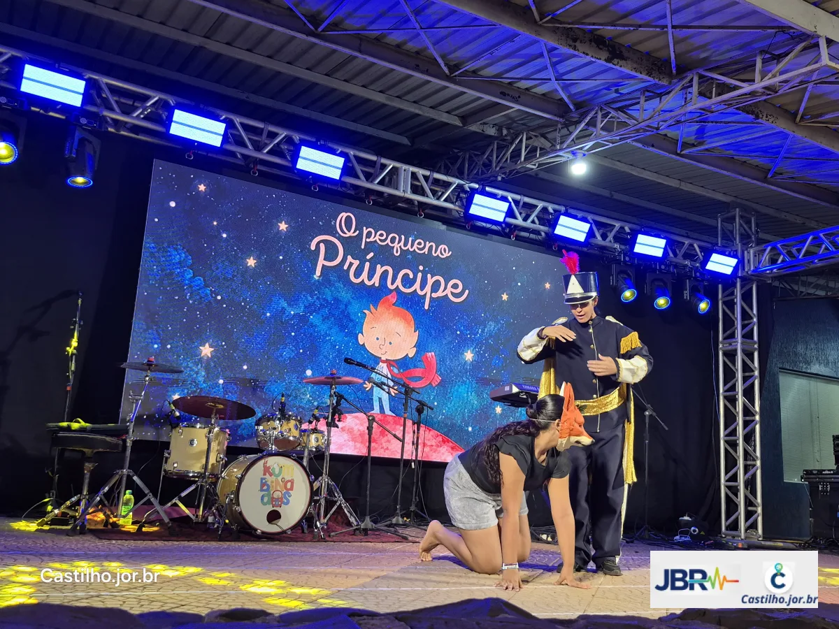 Cena de dança com participantes diante do painel estrelado de O Pequeno Príncipe